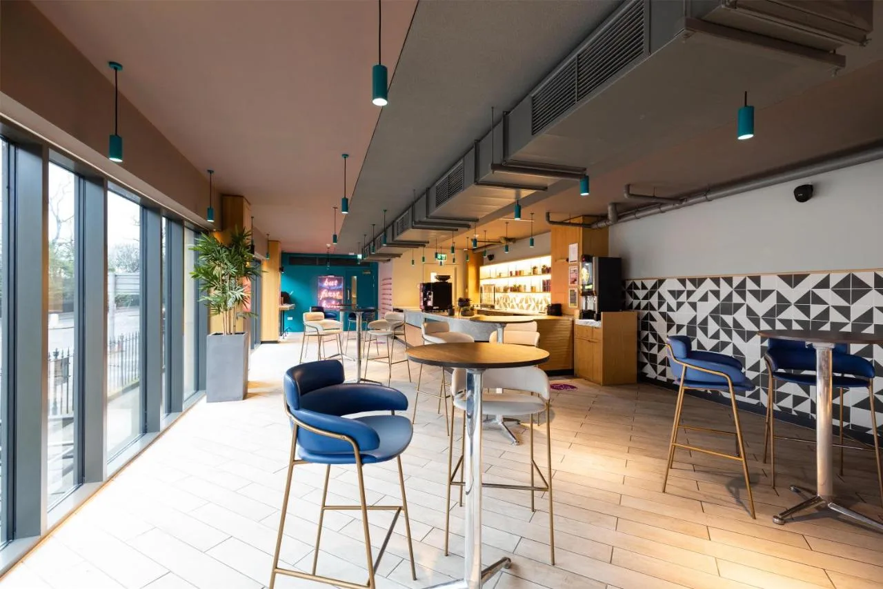 a room with chairs and tables in a building at Yotel Edinburgh in Edinburgh