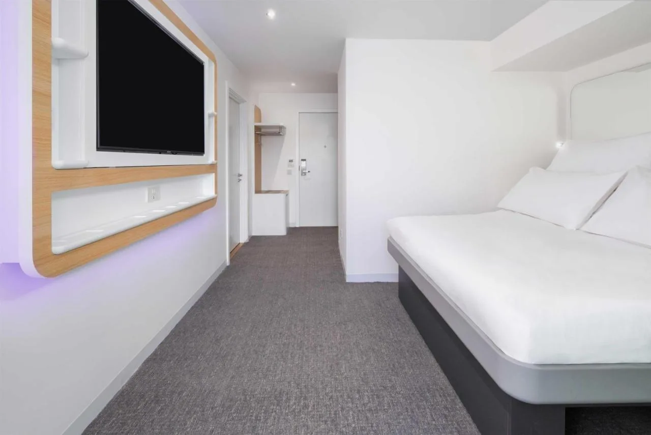a room with a bed and a flat screen tv at Yotel Edinburgh in Edinburgh
