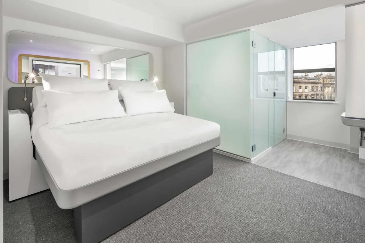 a white bed with white pillows in a bedroom at Yotel Edinburgh in Edinburgh